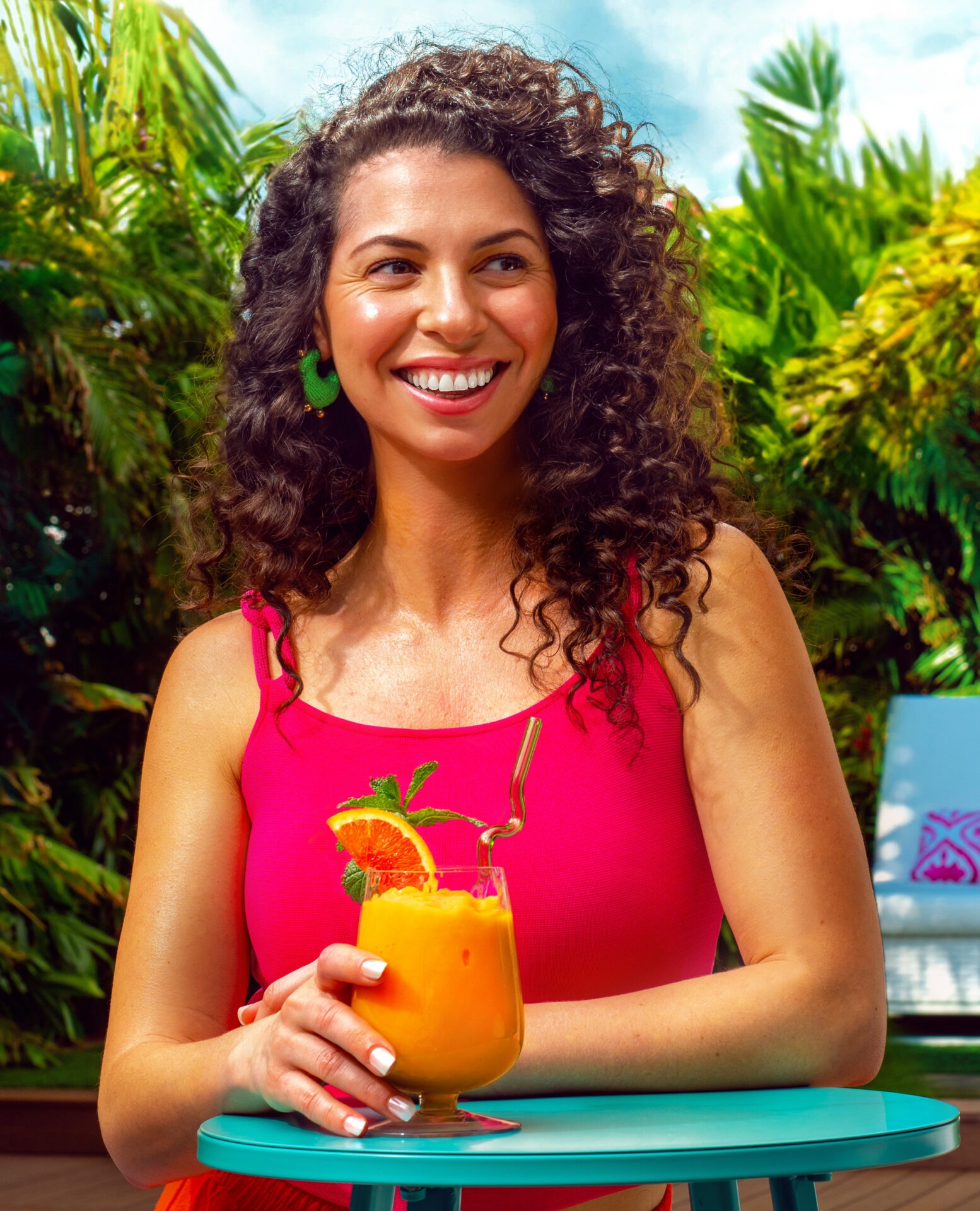 A smiling woman holding a glass of Peelz Cara Cara Berry Smoothie