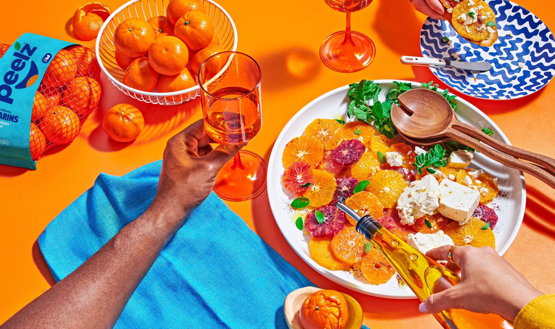 A table with a bowl of Peelz mandarin oranges and a platter of mandarin orange salad.